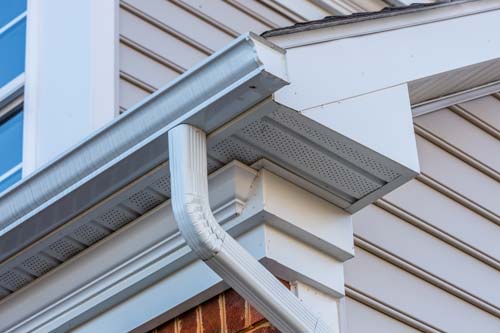 Closeup of a gutter on side of the house.